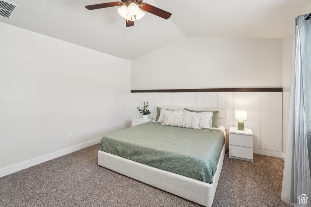 Bedroom with carpet flooring, lofted ceiling, a ceiling fan, and wainscoting