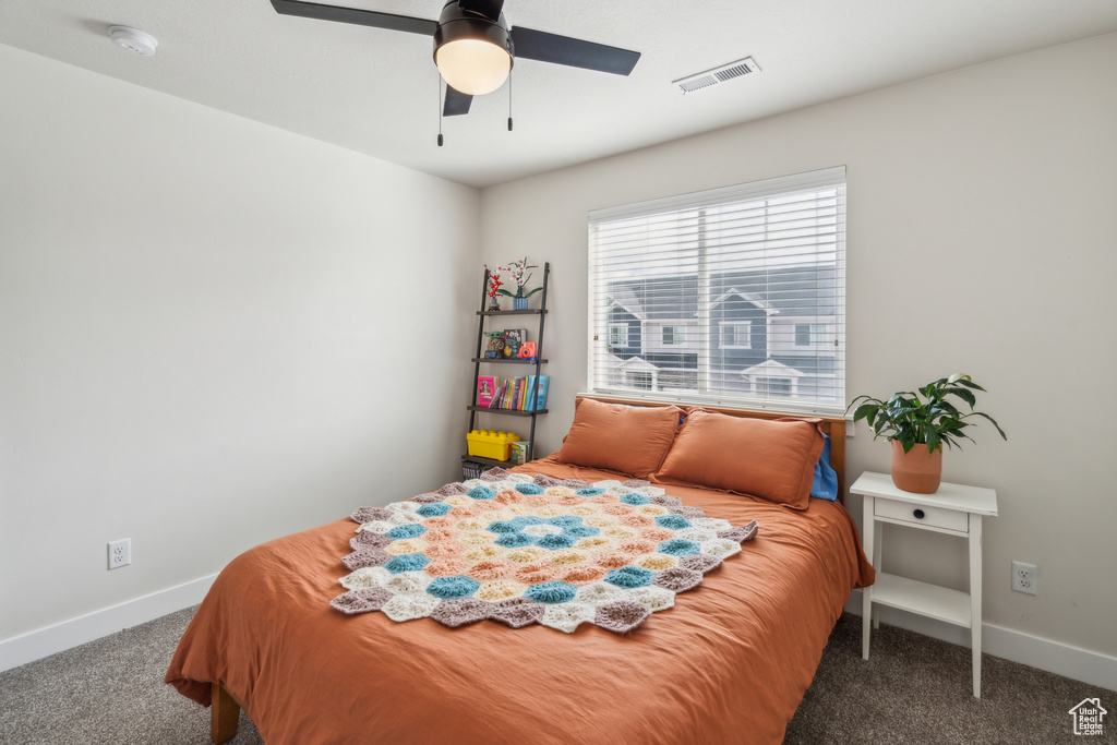 Carpeted bedroom with baseboards and a ceiling fan