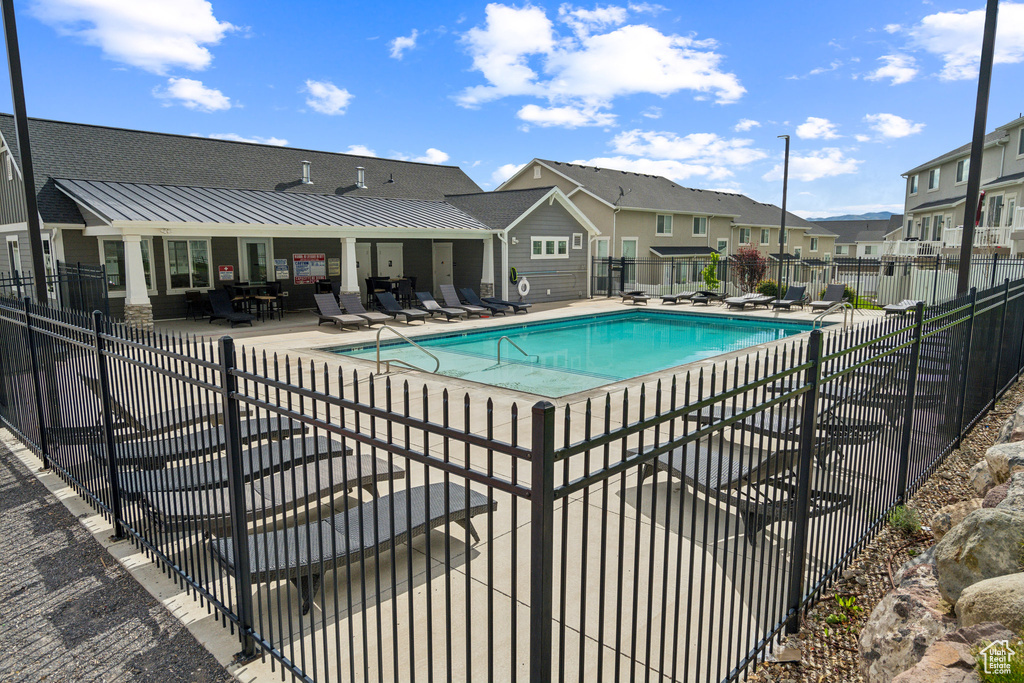 Community pool featuring fence, a residential view, and a patio