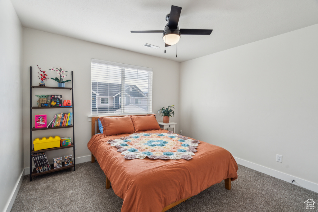 Carpeted bedroom with baseboards and ceiling fan