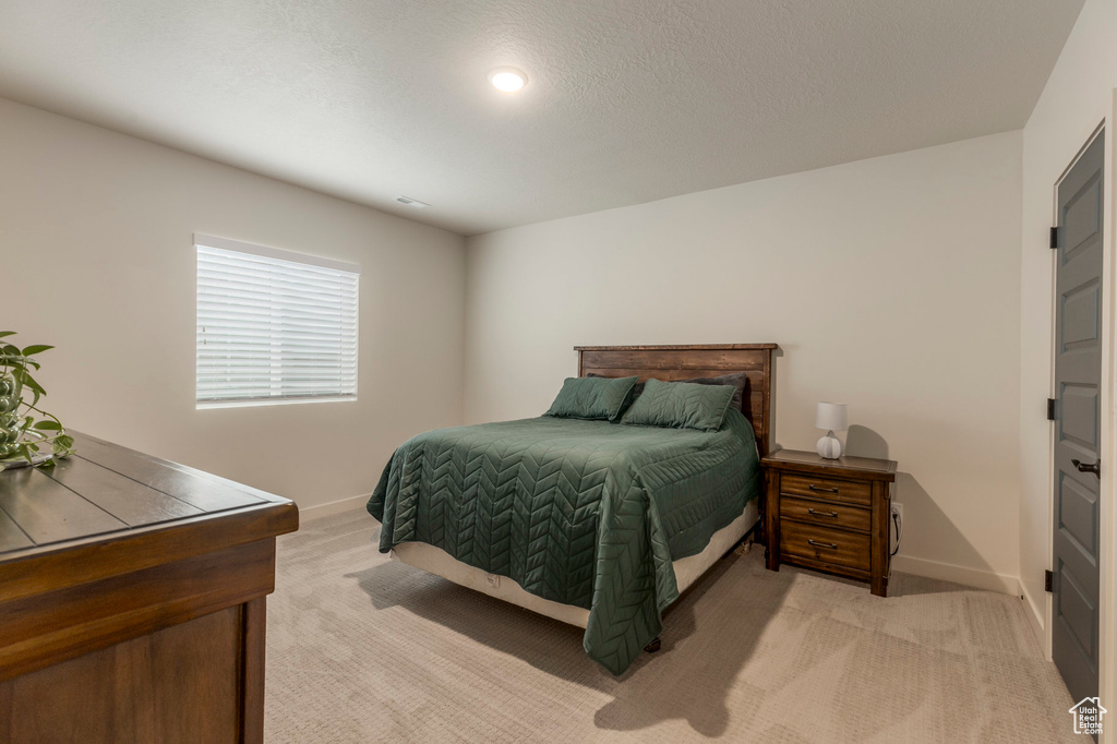 Bedroom featuring light colored carpet and baseboards