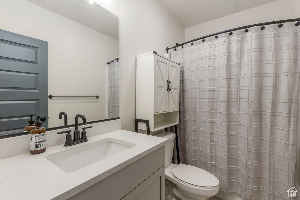 Full bath featuring toilet, vanity, and a shower with shower curtain