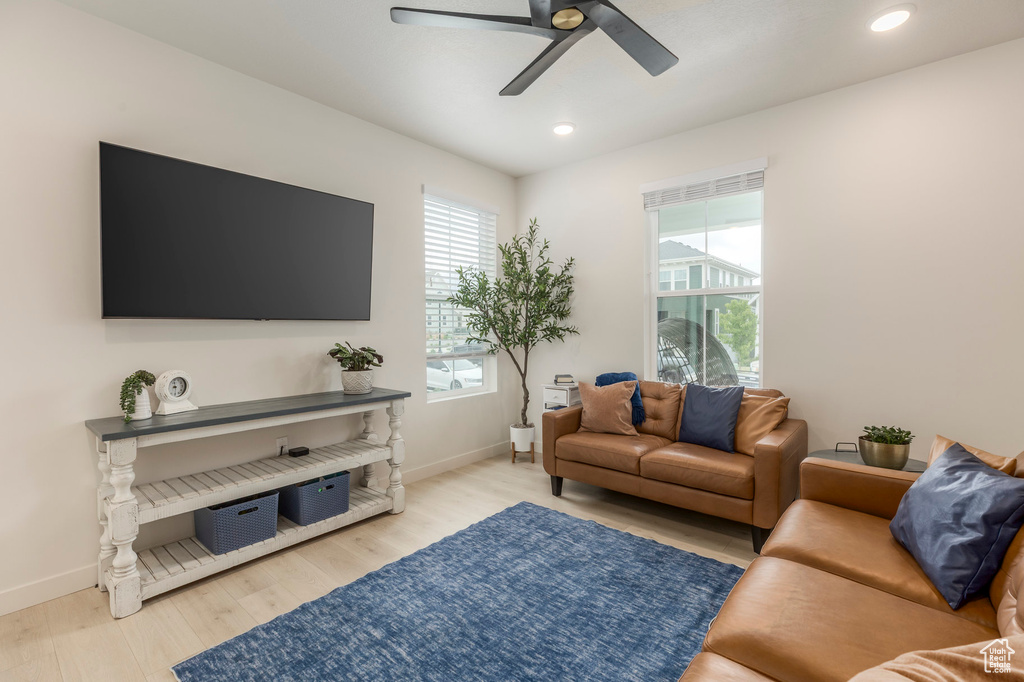 Living area with wood finished floors, ceiling fan, baseboards, and recessed lighting