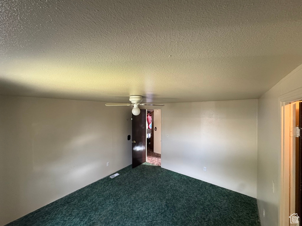 Unfurnished room with carpet, a textured ceiling, and a ceiling fan