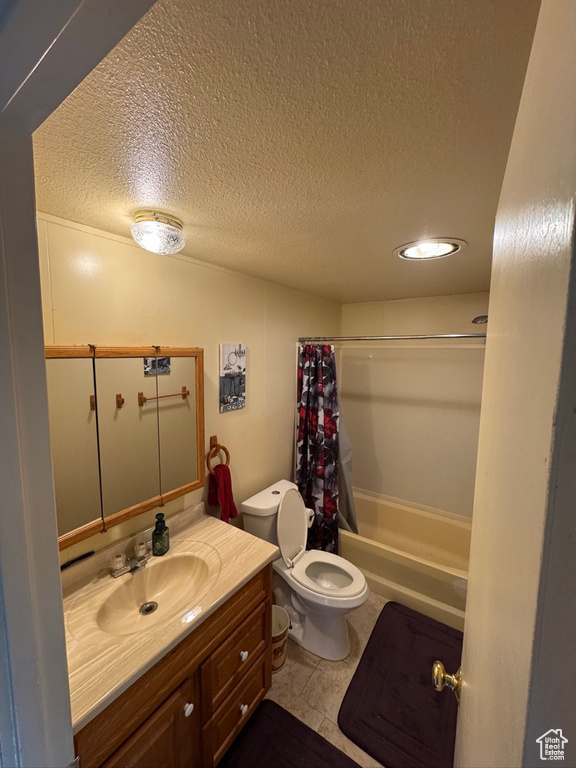 Bathroom featuring a textured ceiling, toilet, shower / bath combination with curtain, vanity, and recessed lighting
