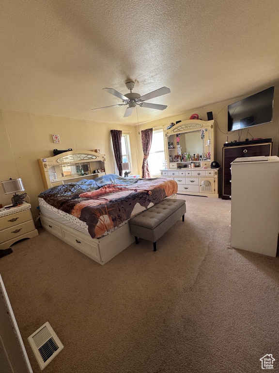 Bedroom with light carpet, a textured ceiling, and a ceiling fan