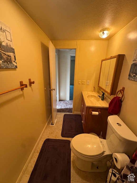 Half bathroom with toilet, a textured ceiling, and vanity