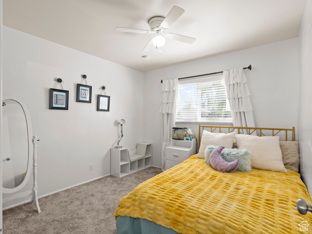 Carpeted bedroom featuring ceiling fan and baseboards