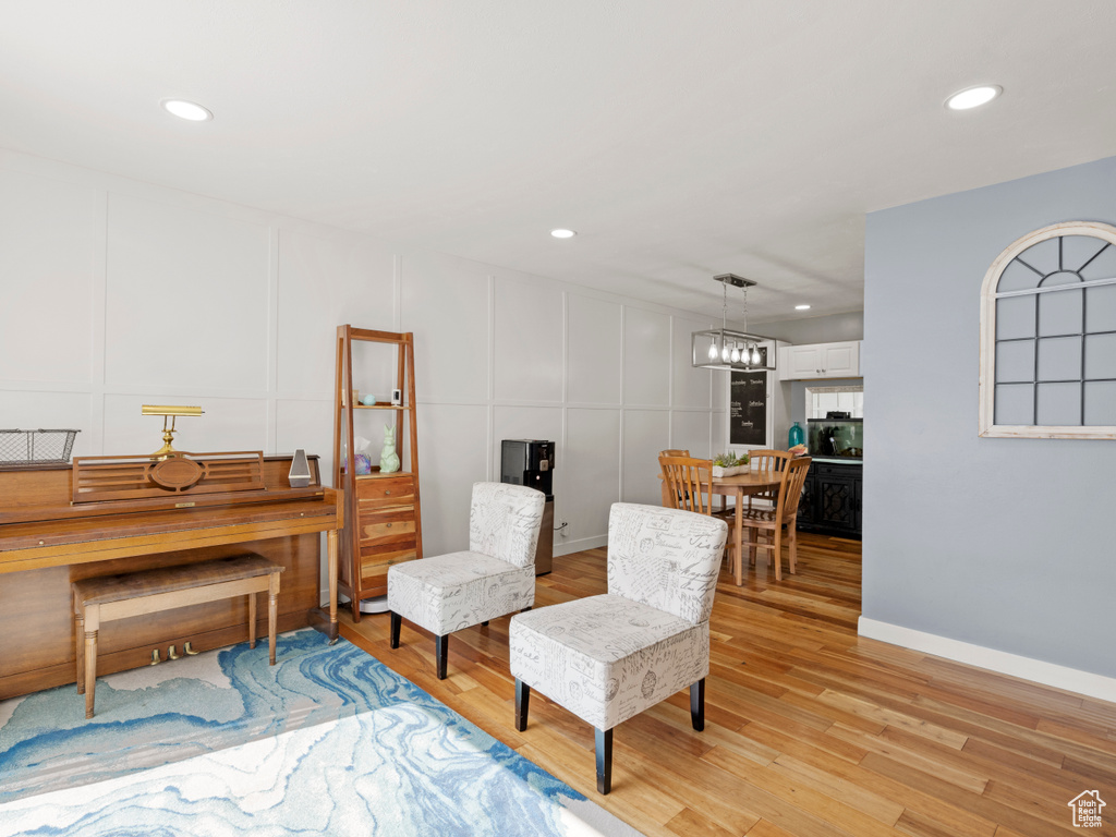 Sitting room with a decorative wall, light wood-type flooring, and recessed lighting