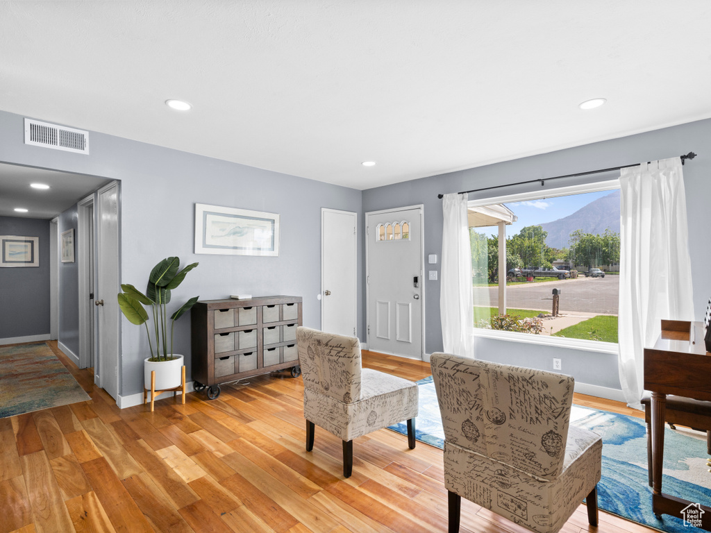 Sitting room featuring a mountain view, light wood-style floors, baseboards, and recessed lighting