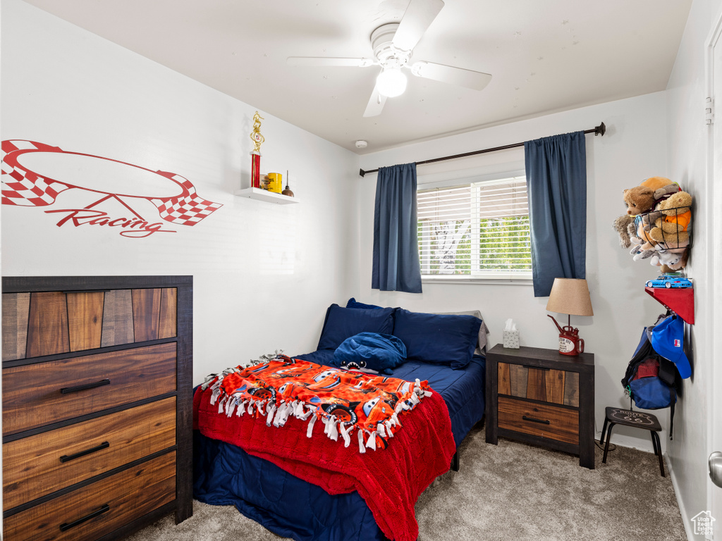 Carpeted bedroom featuring ceiling fan