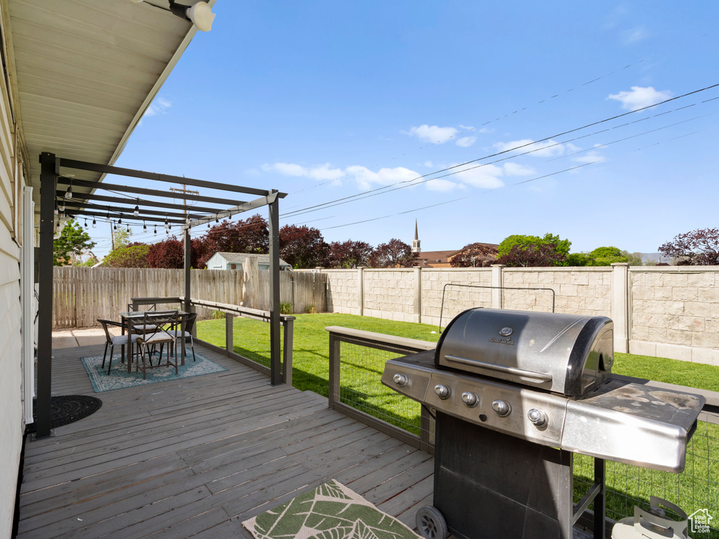 Wooden deck with a grill and outdoor dining area