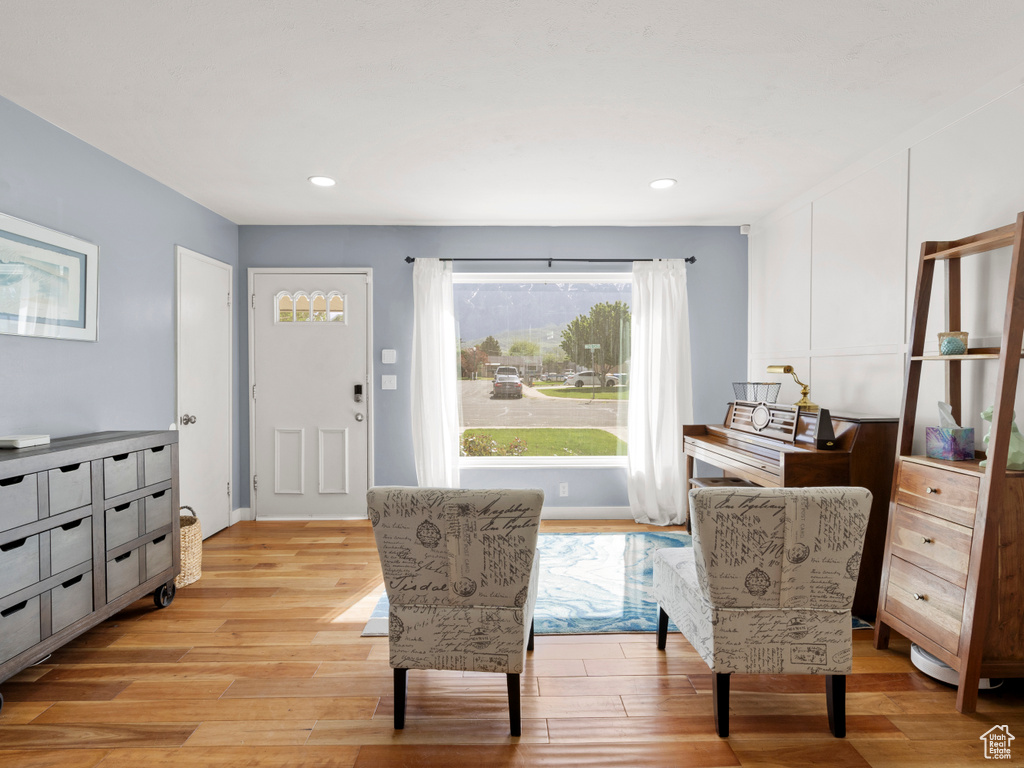 Living area with light wood-style flooring and recessed lighting