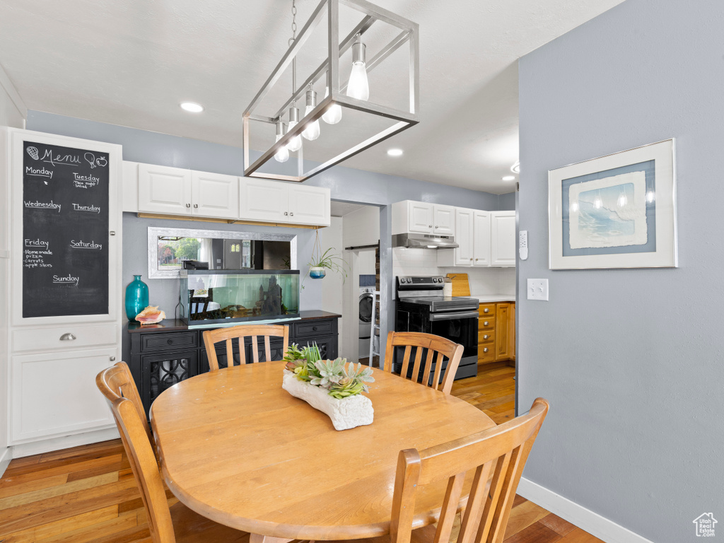 Dining room featuring light wood-style flooring, baseboards, recessed lighting, and washer / clothes dryer