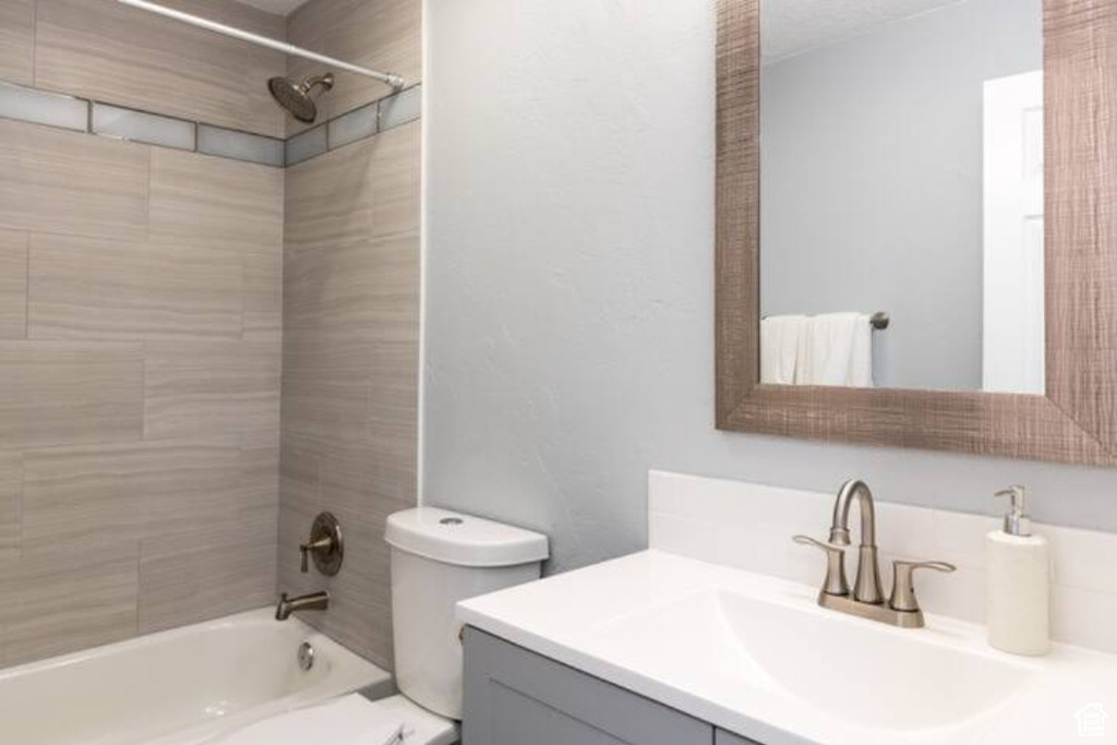 Bathroom featuring vanity, shower / bathtub combination, and toilet