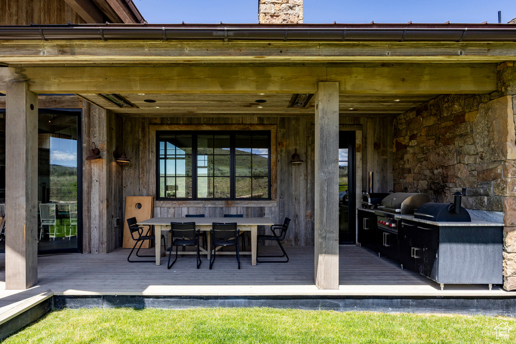 View of patio with a grill, a wooden deck, and outdoor dining space