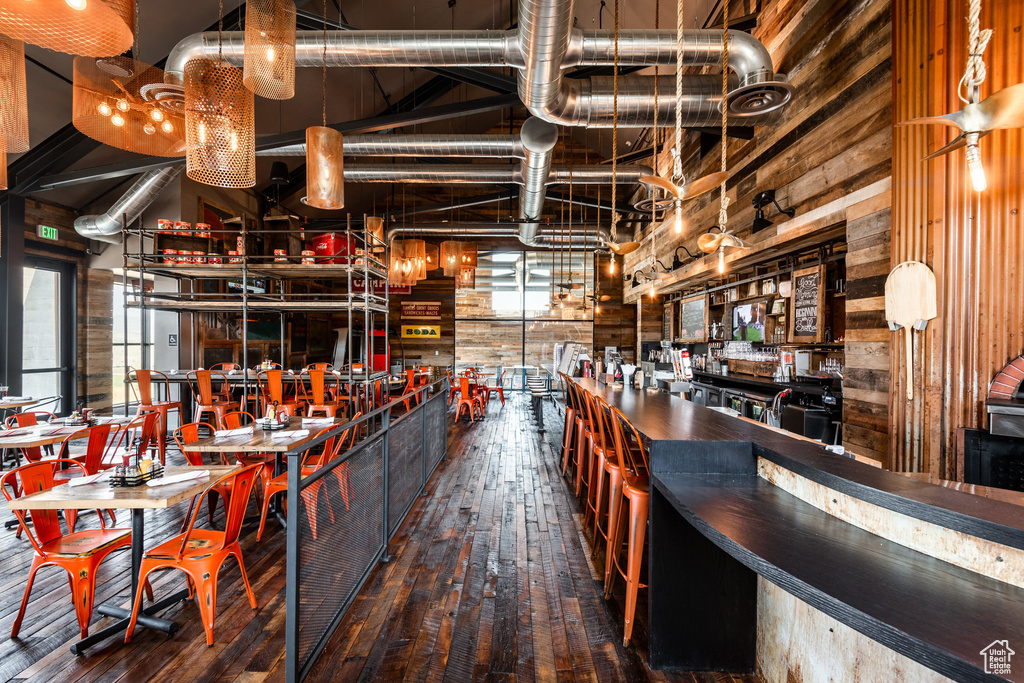 Indoor dry bar with hardwood / wood-style flooring and wooden walls