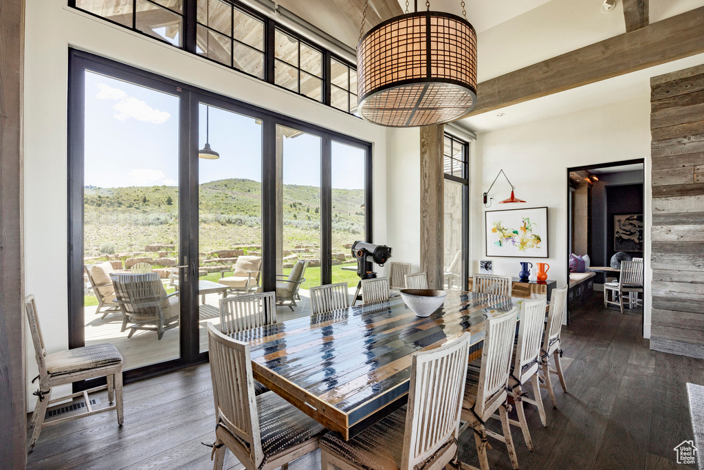 Dining area featuring a towering ceiling, dark wood-style floors, and a mountain view