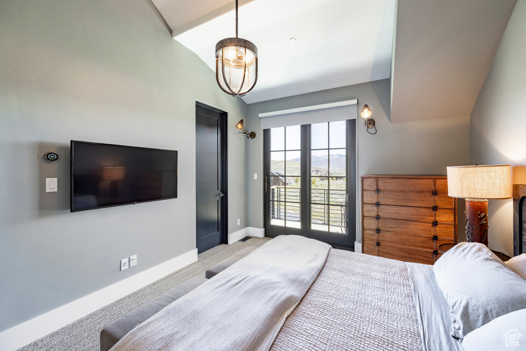 Bedroom featuring baseboards, light colored carpet, and lofted ceiling