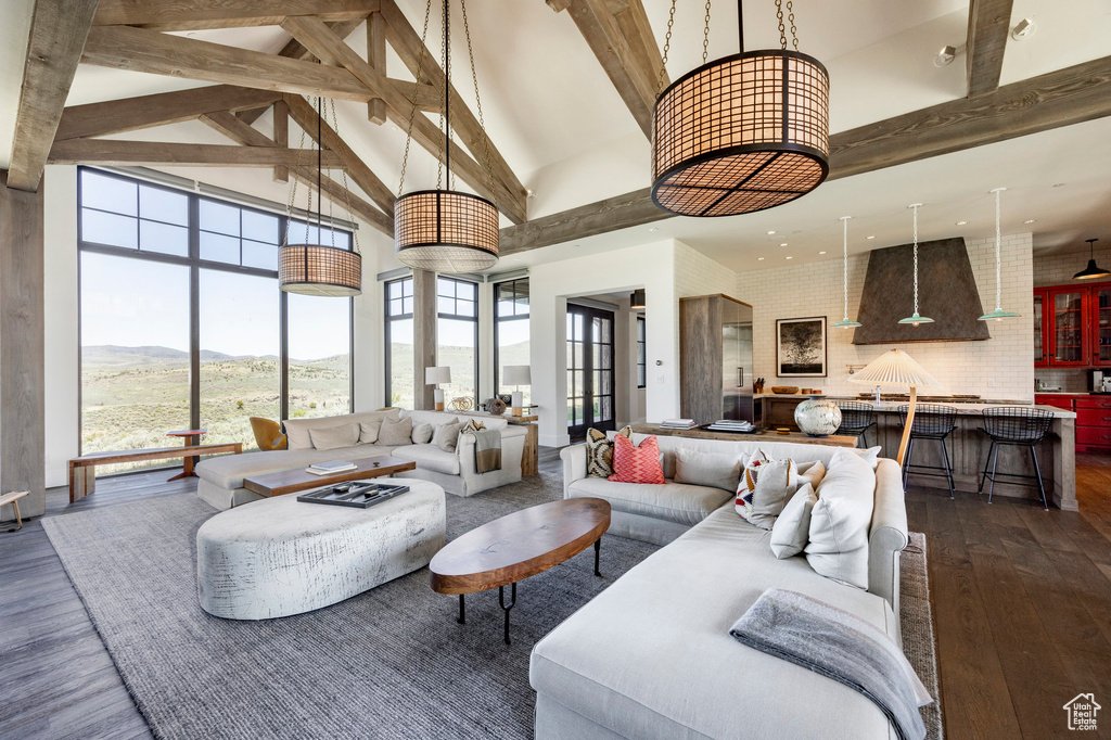 Living room featuring high vaulted ceiling, dark wood-style floors, beam ceiling, and a mountain view