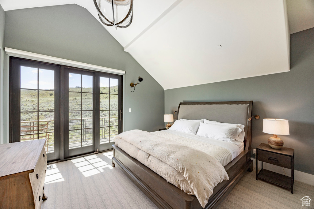 Bedroom featuring lofted ceiling, access to outside, and light carpet