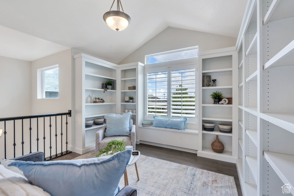 Sitting room with wood finished floors, healthy amount of natural light, and lofted ceiling