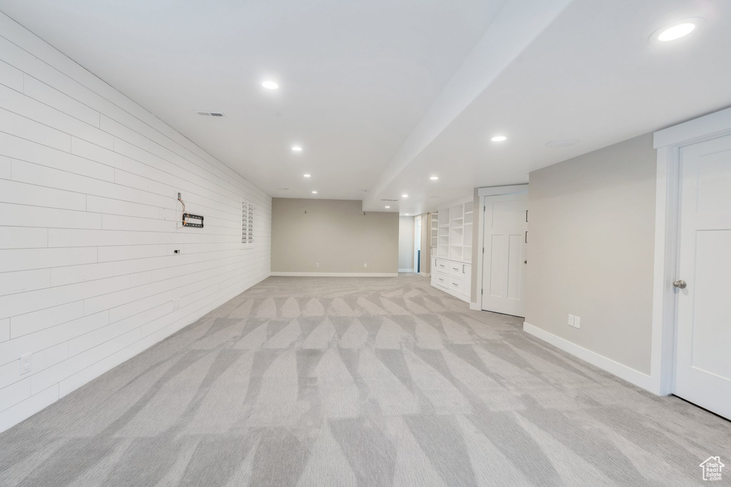 Finished below grade area featuring recessed lighting, light colored carpet, and baseboards