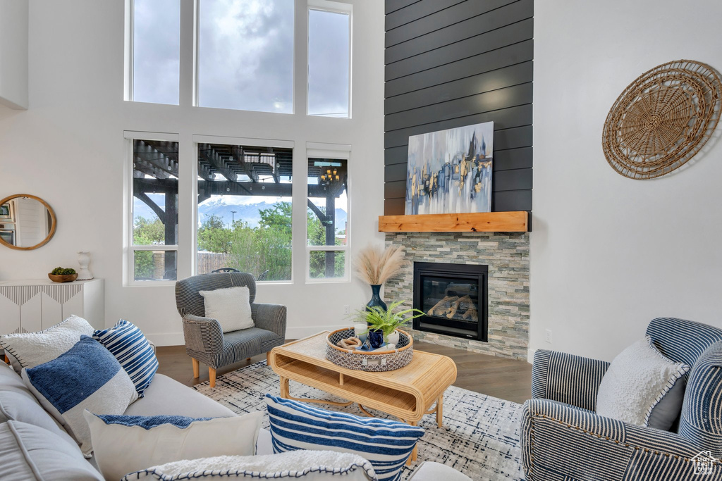 Living area featuring a high ceiling, wood finished floors, and a fireplace