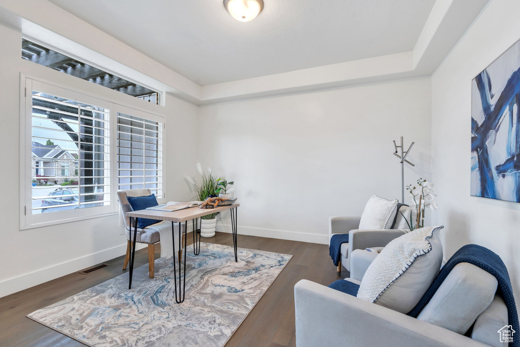 Office area featuring wood finished floors, baseboards, and a tray ceiling