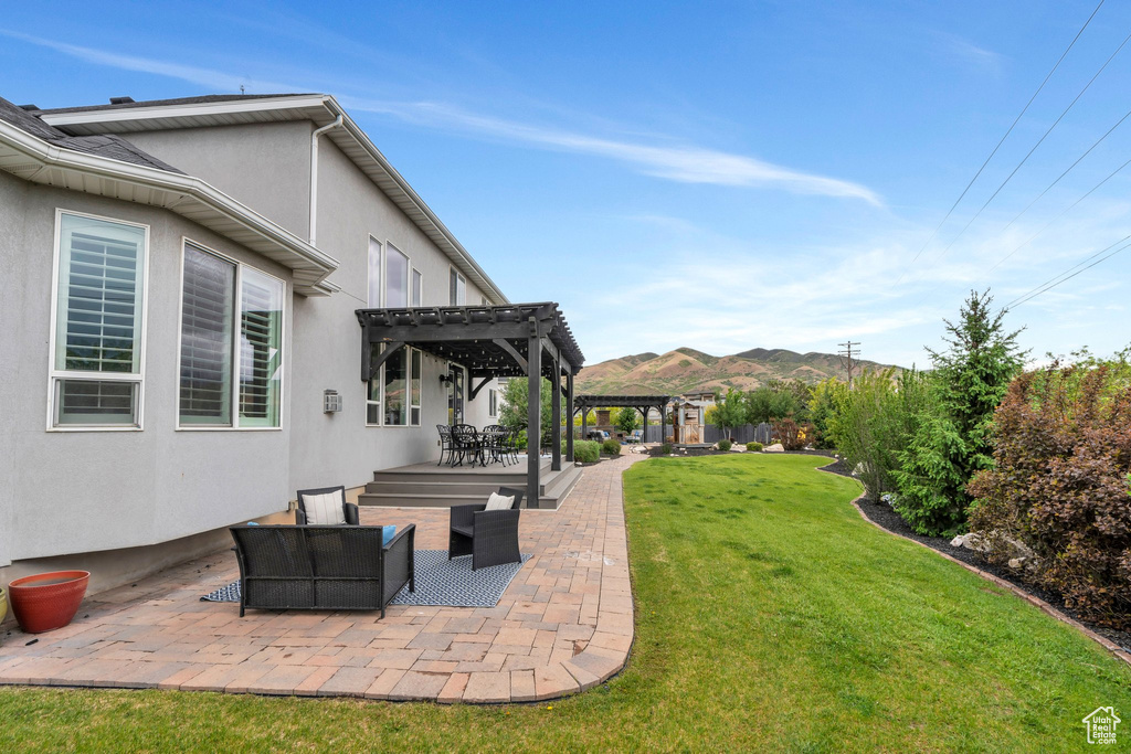 View of grassy yard featuring a pergola, a patio area, a mountain view, and an outdoor hangout area