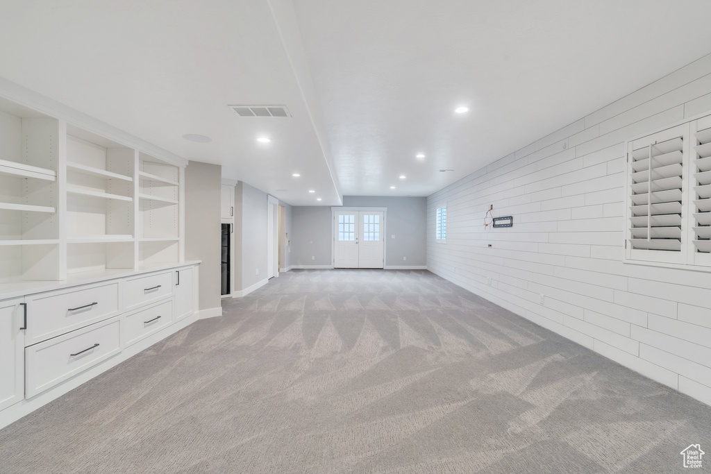 Unfurnished living room with light carpet, recessed lighting, and baseboards