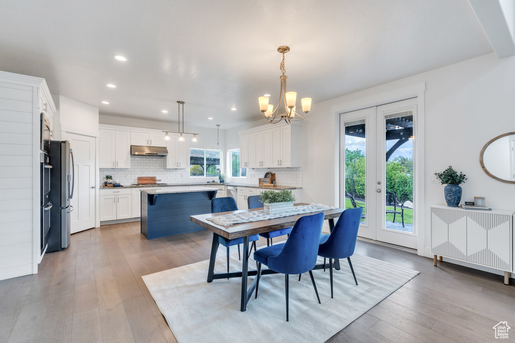 Dining space with a chandelier, light wood-style flooring, and recessed lighting