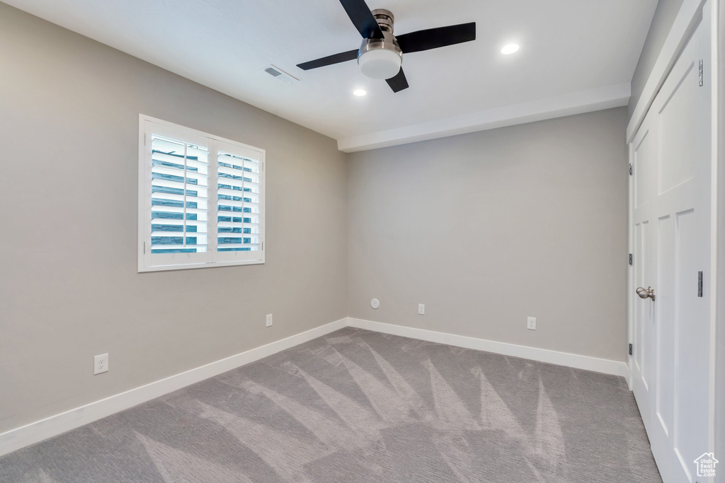 Carpeted spare room with a ceiling fan, baseboards, and recessed lighting