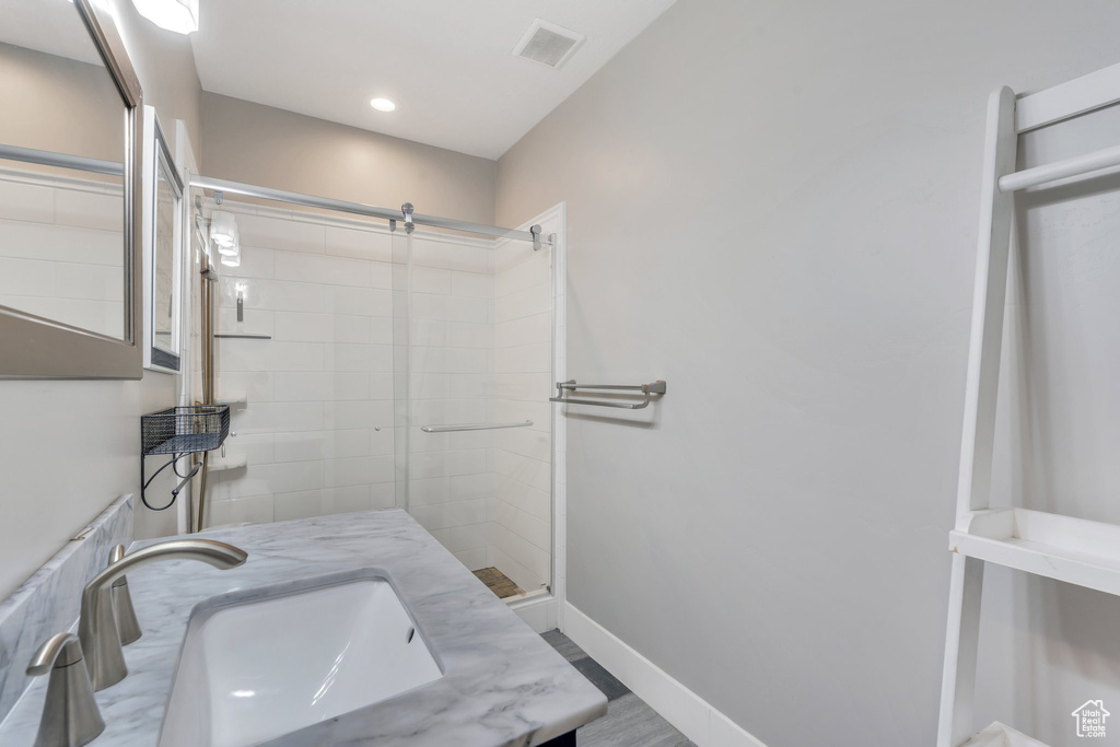 Bathroom featuring a shower stall, baseboards, and vanity