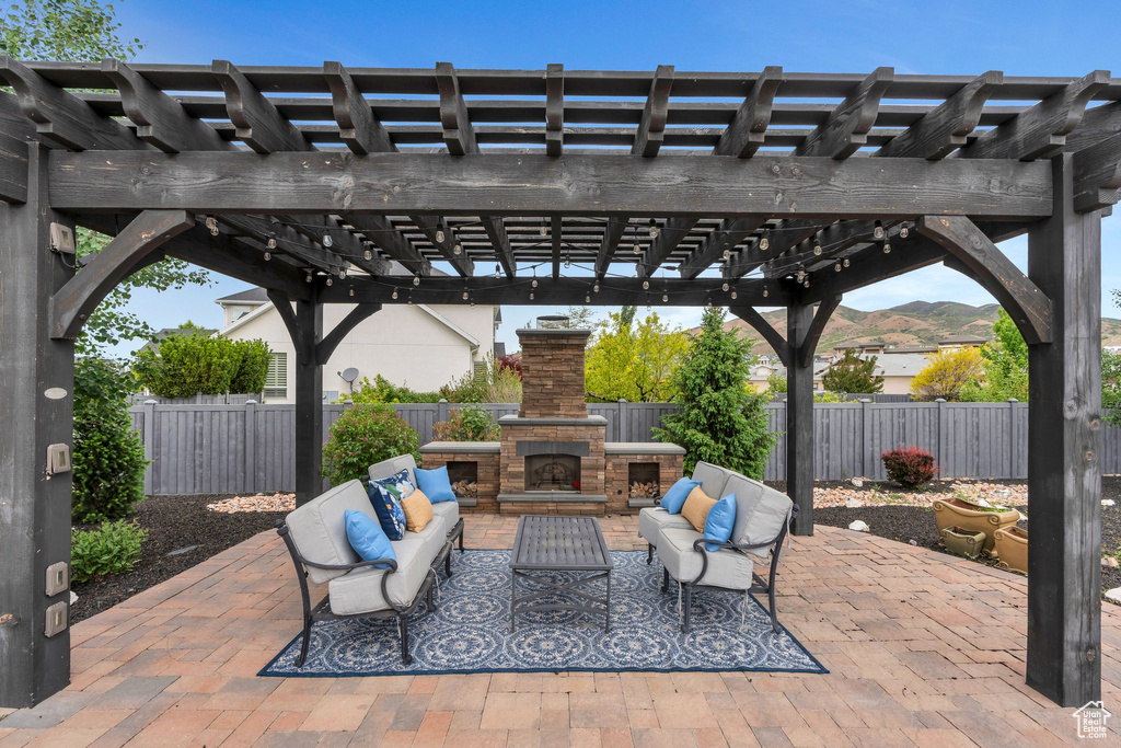 View of patio featuring an outdoor living space with a fireplace, a fenced backyard, and a pergola