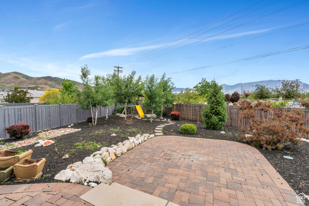 View of patio with a mountain view and a fenced backyard