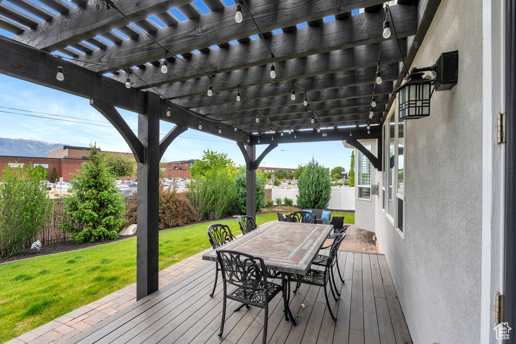 Wooden terrace featuring a pergola, outdoor dining area, and a mountain view