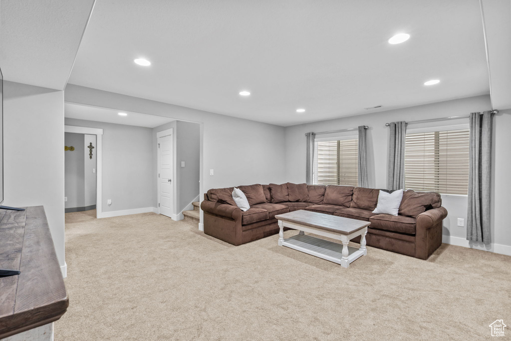 Living room featuring light colored carpet, recessed lighting, baseboards, and stairs