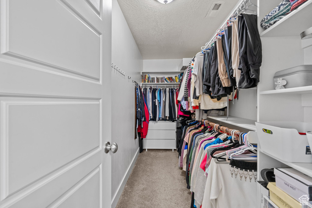 Walk in closet featuring carpet flooring