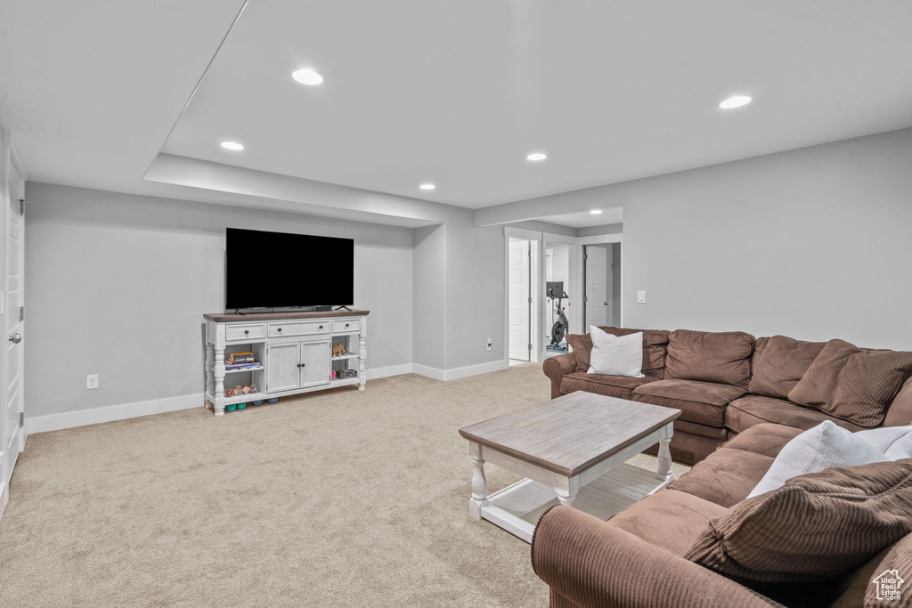 Carpeted living area with recessed lighting and baseboards