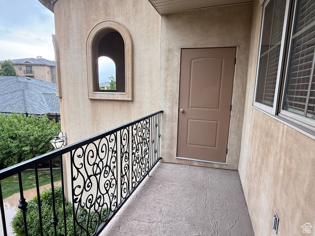 Doorway to property with a balcony and stucco siding