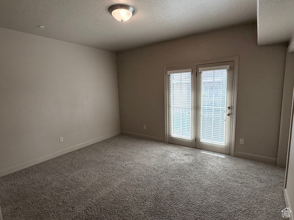 Carpeted spare room with baseboards and a textured ceiling