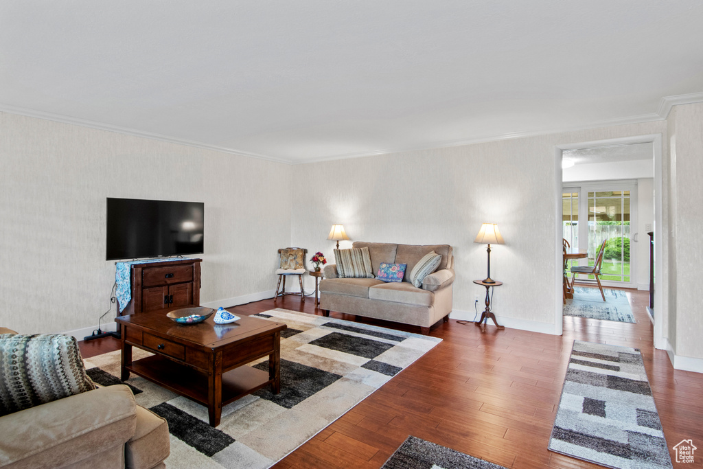 Living area with ornamental molding, hardwood / wood-style flooring, and baseboards