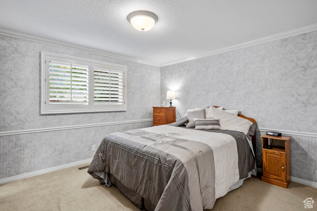 Bedroom featuring crown molding, carpet, and baseboards