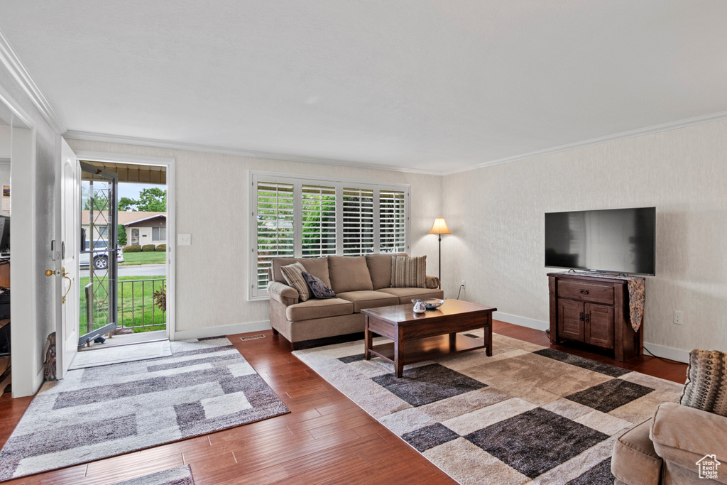 Living room with crown molding, wood finished floors, and baseboards