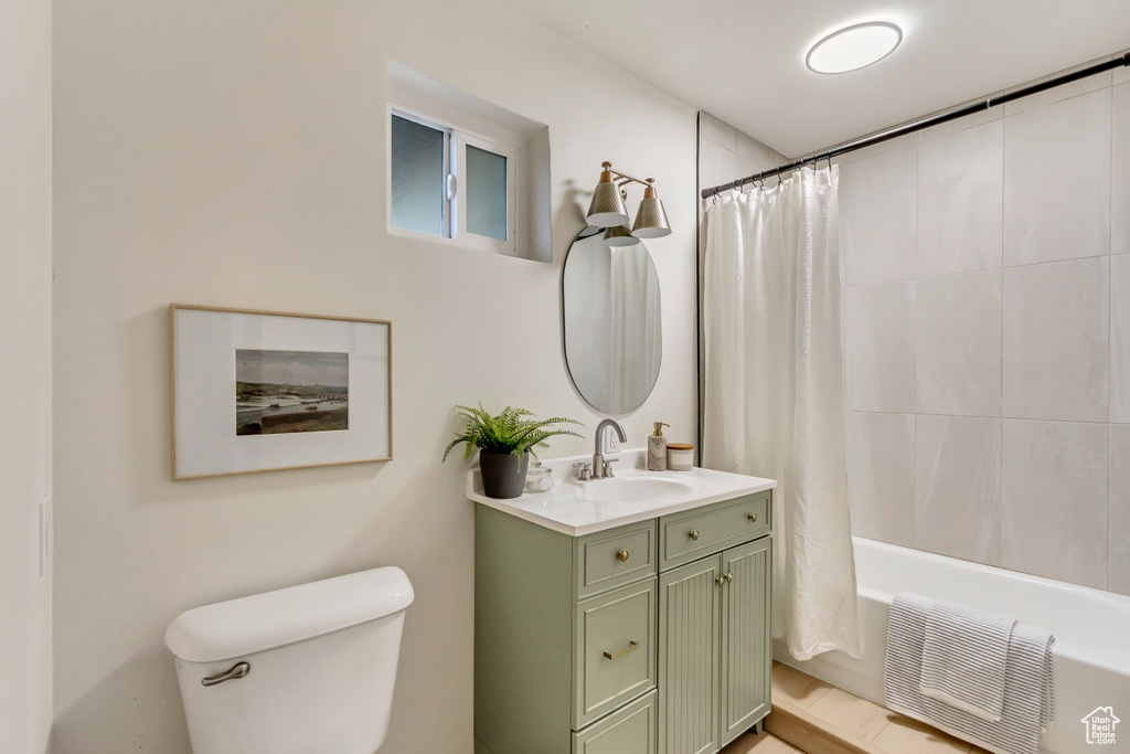 Full bath featuring toilet, vanity, and shower / tub combo