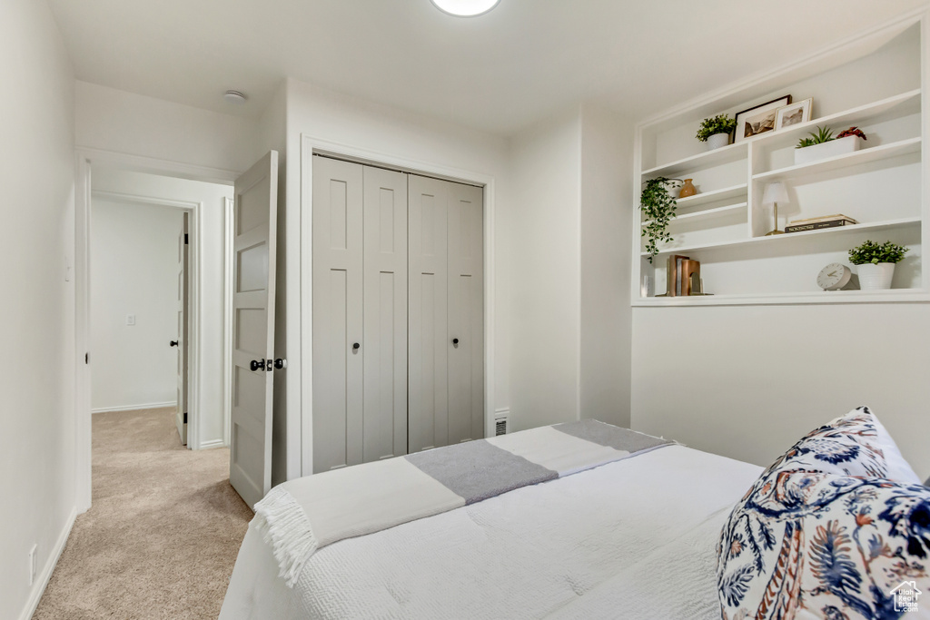 Bedroom with carpet flooring, a closet, and baseboards