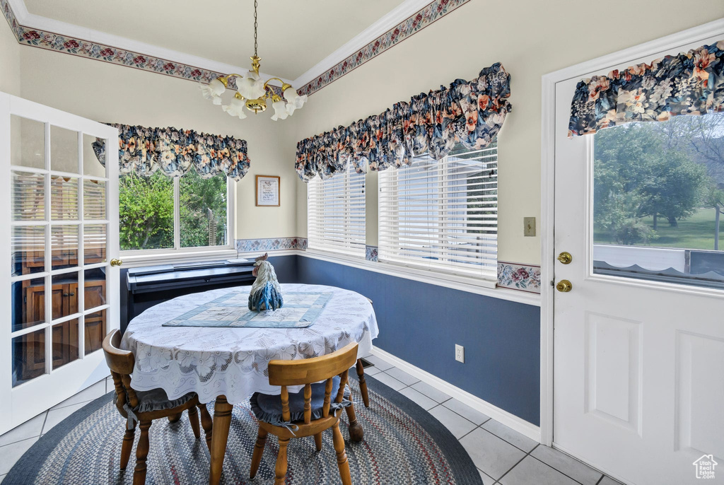 Dining area with a chandelier, tile patterned floors, and baseboards