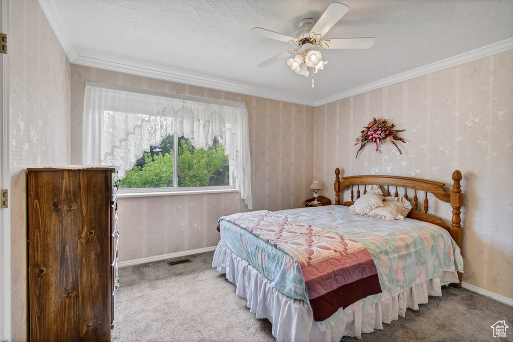 Bedroom with carpet flooring, baseboards, ornamental molding, and a ceiling fan