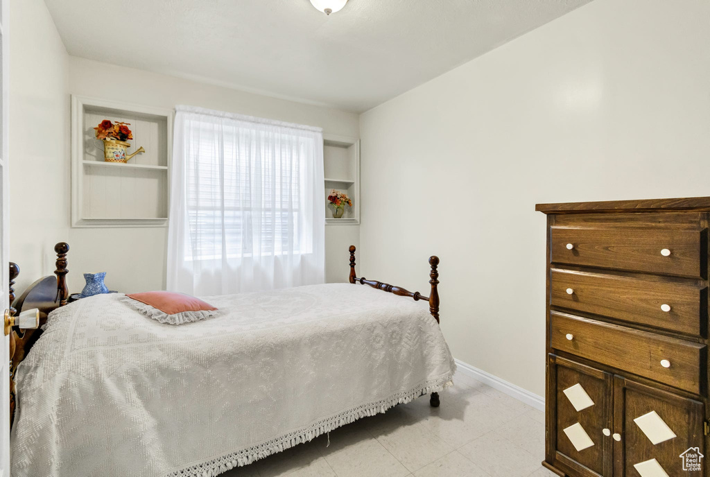 Bedroom with baseboards and light floors